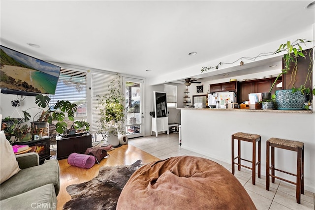 living room featuring light tile patterned floors and ceiling fan