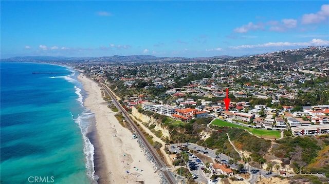 birds eye view of property with a water view and a beach view