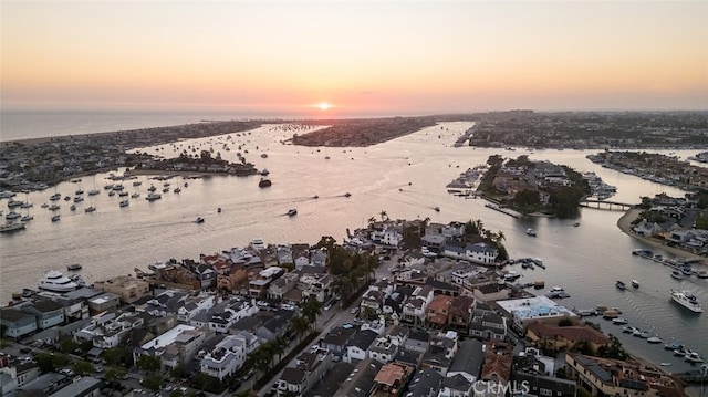 aerial view at dusk featuring a water view