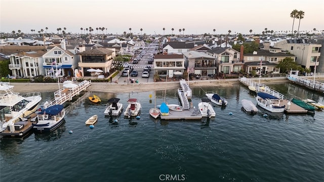 aerial view at dusk featuring a water view