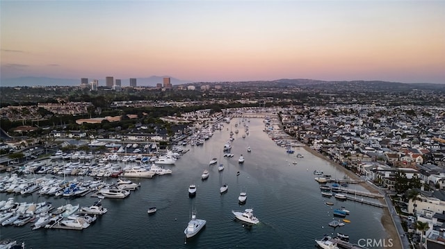 aerial view at dusk featuring a water view