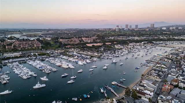 aerial view at dusk featuring a water view