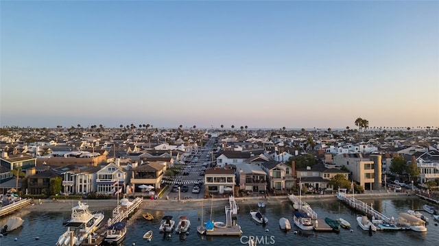 aerial view at dusk featuring a water view