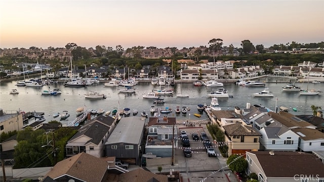 aerial view at dusk featuring a water view