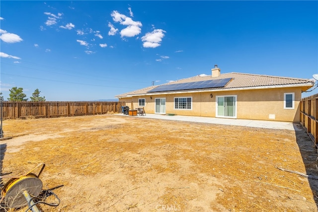 back of house featuring a patio and solar panels