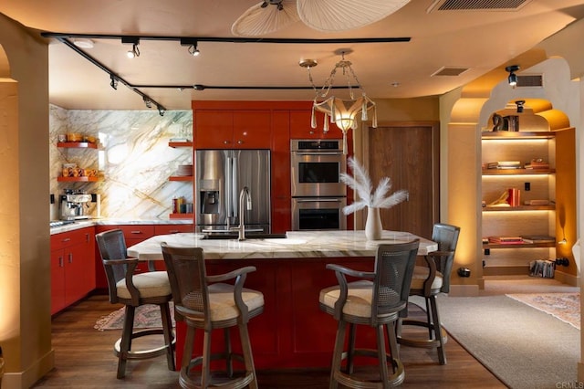 kitchen featuring appliances with stainless steel finishes, sink, dark hardwood / wood-style floors, and a kitchen breakfast bar