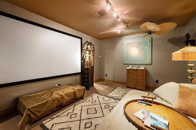 cinema room featuring light colored carpet, rail lighting, and ceiling fan