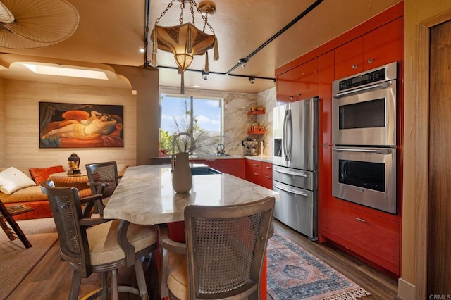 kitchen with stainless steel appliances and dark hardwood / wood-style flooring