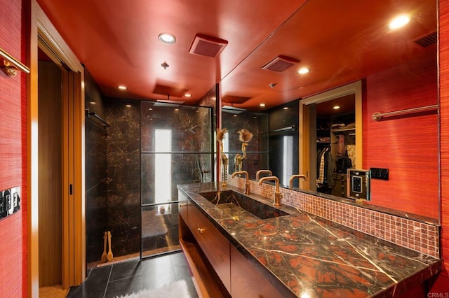 bathroom featuring vanity, an enclosed shower, tile patterned flooring, and backsplash