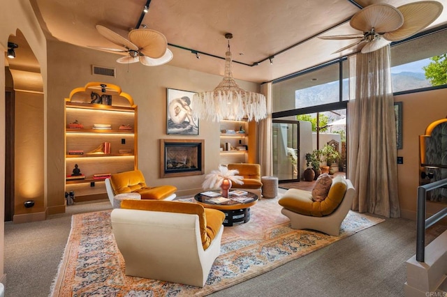 carpeted living room with ceiling fan and rail lighting