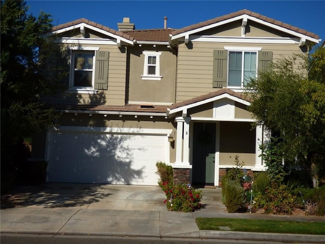 craftsman inspired home featuring concrete driveway, a tile roof, and an attached garage