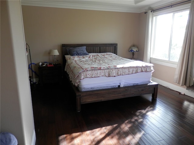 bedroom with ornamental molding and dark wood-type flooring