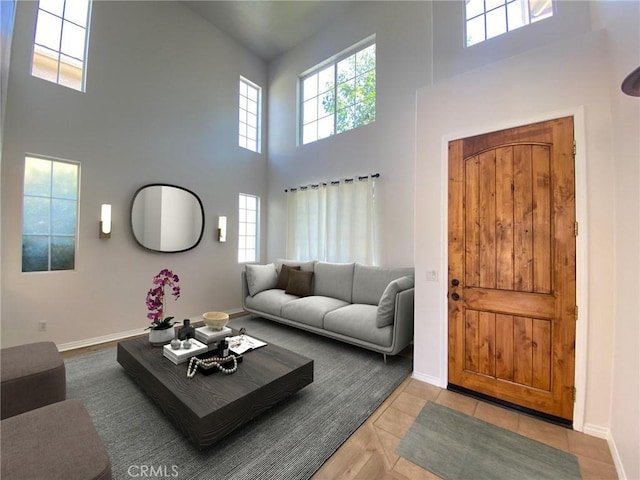 living room with light tile patterned floors and a high ceiling