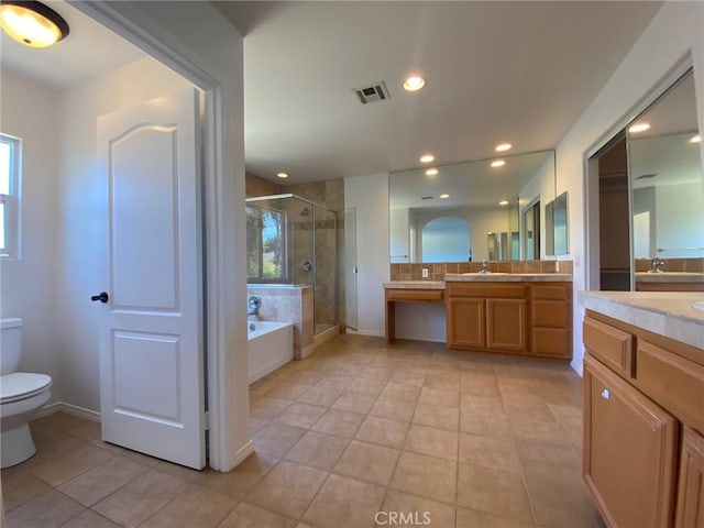 full bathroom with toilet, vanity, tile patterned floors, a wealth of natural light, and independent shower and bath