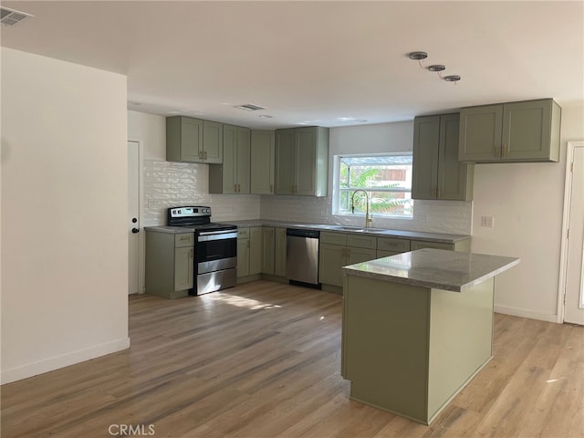 kitchen featuring light hardwood / wood-style floors, appliances with stainless steel finishes, tasteful backsplash, and sink