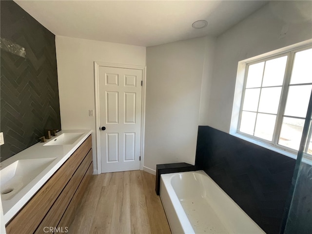 bathroom featuring a bathing tub, vanity, and hardwood / wood-style flooring