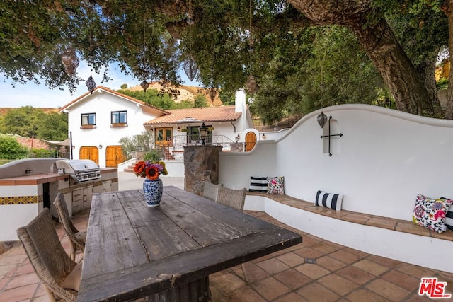 view of patio featuring an outdoor kitchen and a grill