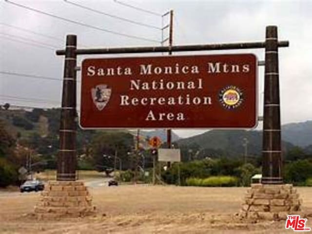 community / neighborhood sign with a mountain view