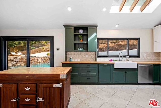 kitchen featuring backsplash, a skylight, sink, dishwasher, and butcher block counters