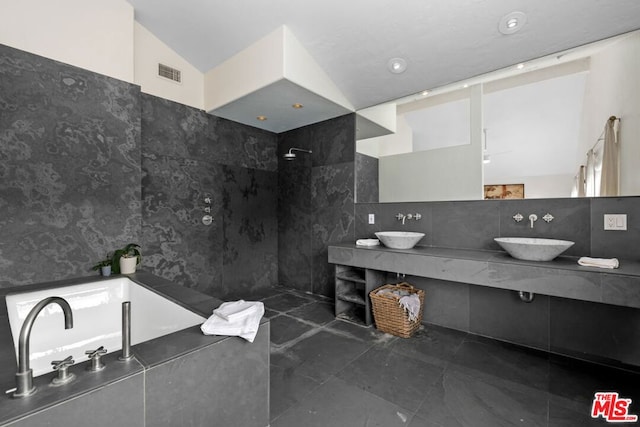 bathroom with tile patterned flooring, vanity, walk in shower, and lofted ceiling