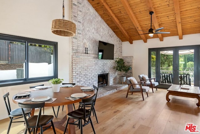 dining room featuring beam ceiling, light hardwood / wood-style floors, and high vaulted ceiling