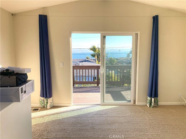 doorway featuring lofted ceiling and carpet flooring