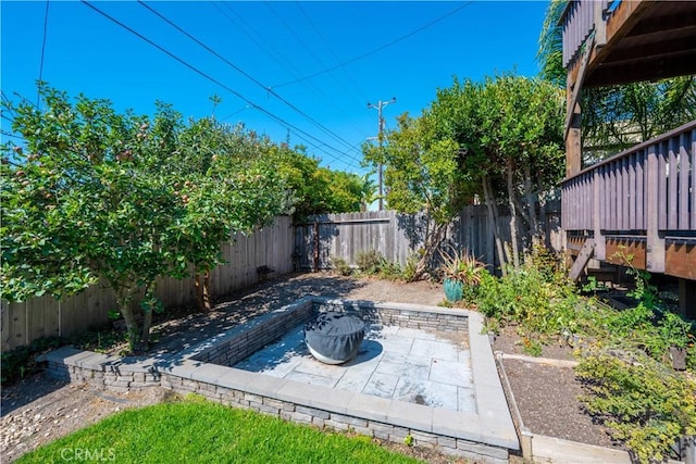 exterior space with a deck, a fire pit, and a patio