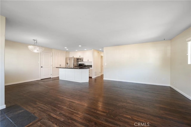 unfurnished living room with dark hardwood / wood-style flooring and an inviting chandelier