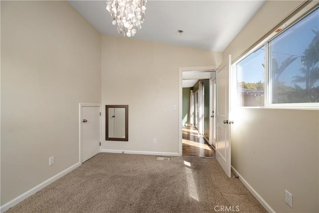 unfurnished room featuring vaulted ceiling and a chandelier