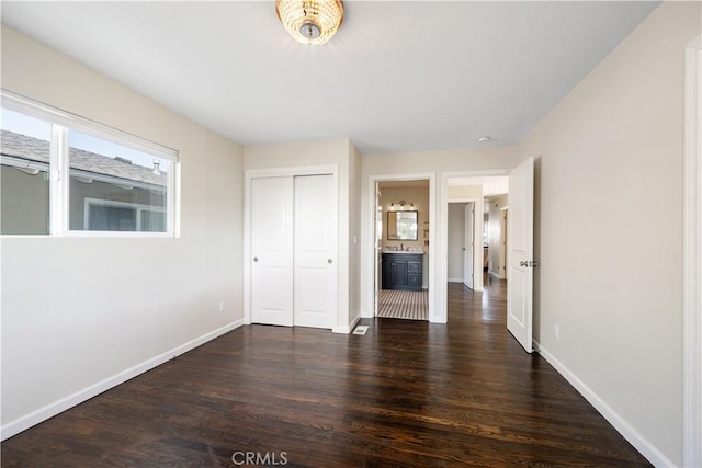 unfurnished bedroom featuring dark hardwood / wood-style flooring and a closet