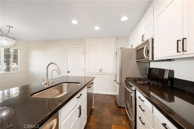 kitchen with white cabinetry, appliances with stainless steel finishes, sink, and pendant lighting