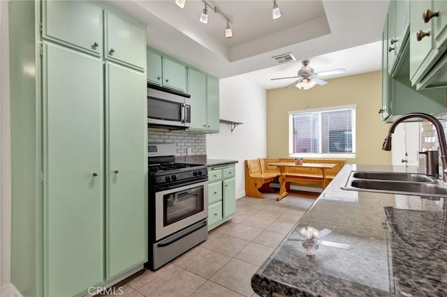 kitchen featuring ceiling fan, light tile patterned flooring, sink, appliances with stainless steel finishes, and green cabinets