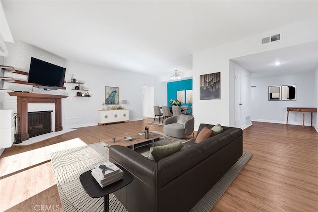 living room with light hardwood / wood-style floors and a notable chandelier