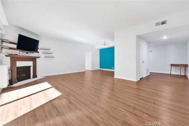 unfurnished living room featuring a chandelier and hardwood / wood-style flooring