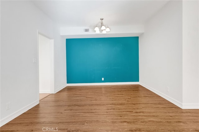 unfurnished dining area featuring a notable chandelier and wood-type flooring