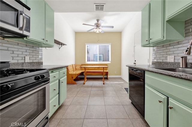 kitchen with light tile patterned floors, stainless steel appliances, backsplash, and green cabinets