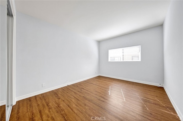 unfurnished room with wood-type flooring