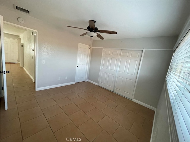 unfurnished bedroom with vaulted ceiling, ceiling fan, tile patterned floors, and a closet