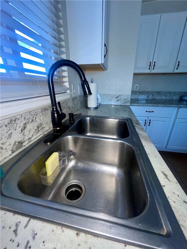 interior details featuring white cabinetry and sink