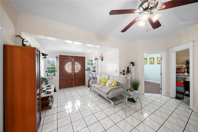 living room featuring light tile patterned floors, a textured ceiling, and ceiling fan