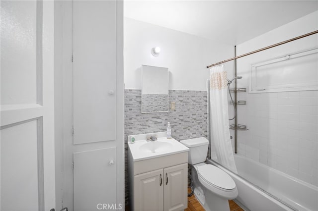 full bathroom featuring vanity, toilet, shower / bathtub combination with curtain, and tile walls