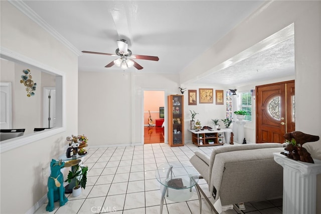 tiled living room featuring ceiling fan and crown molding