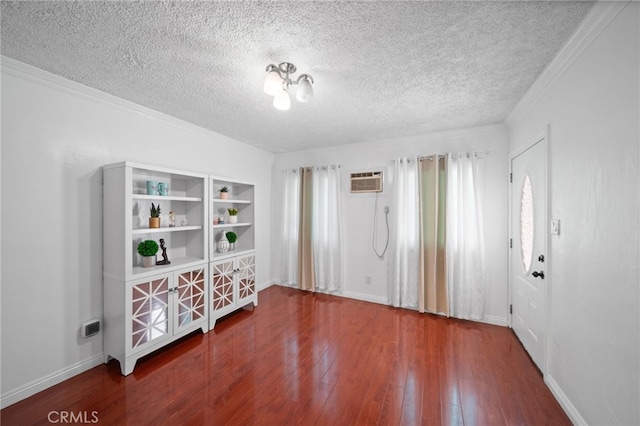 interior space with a wall mounted air conditioner, a textured ceiling, hardwood / wood-style flooring, and ornamental molding