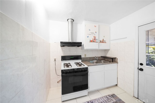 kitchen featuring white cabinetry, sink, white stove, light tile patterned floors, and tile walls