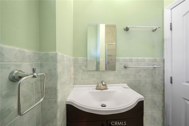 bathroom featuring vanity and tile walls