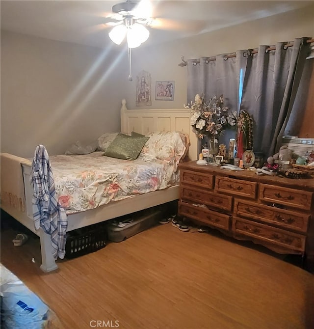 bedroom with ceiling fan and hardwood / wood-style flooring