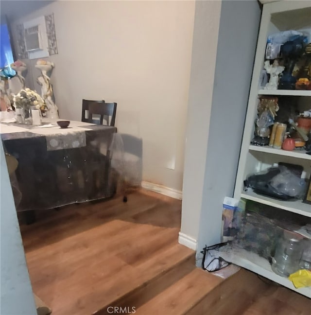 interior space featuring a wall mounted air conditioner and hardwood / wood-style flooring