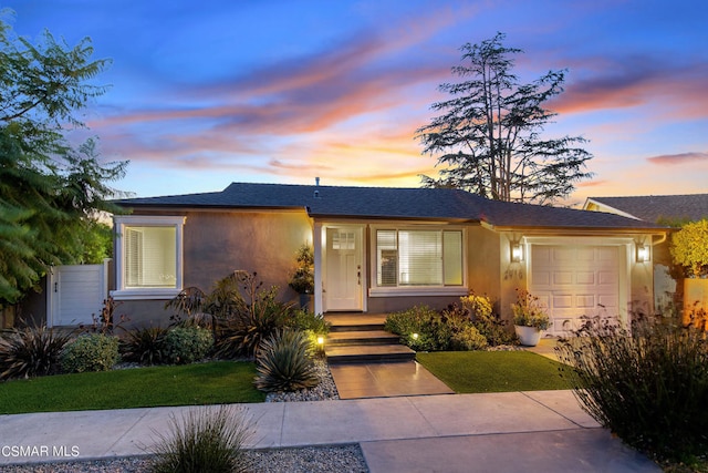 view of front of home with a yard and a garage