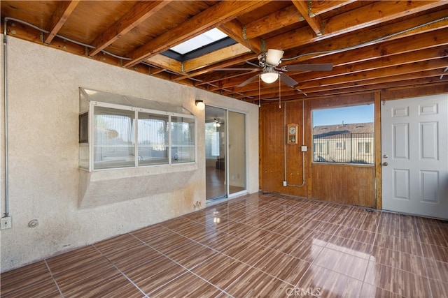 interior space featuring ceiling fan and a skylight