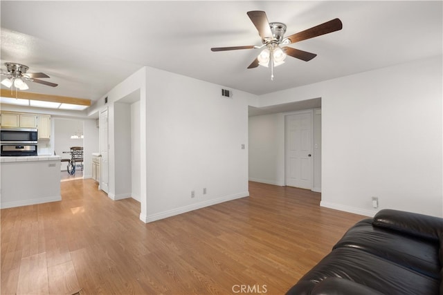 living room featuring ceiling fan and light hardwood / wood-style flooring